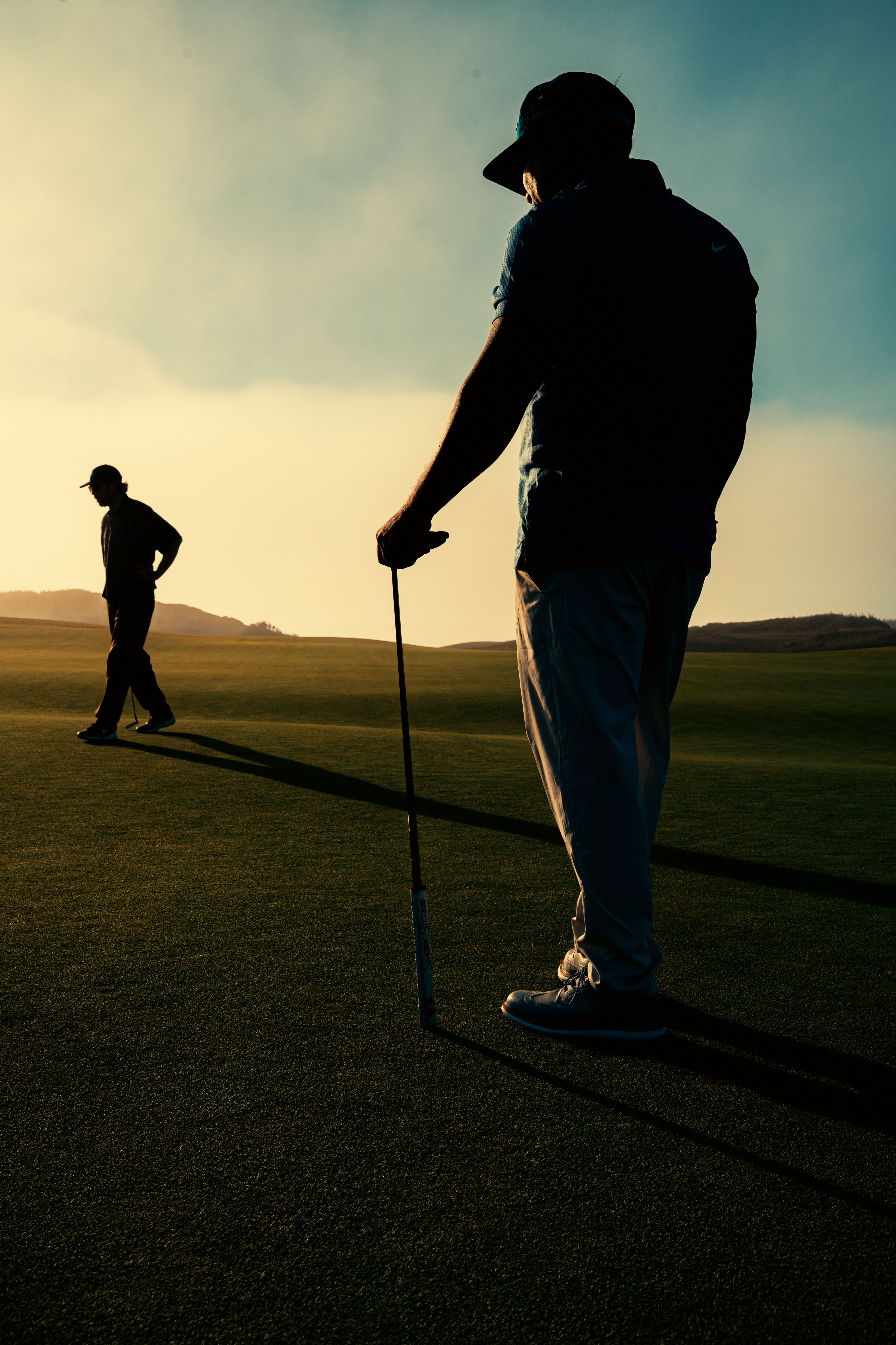 Golfer playing an approach shot across a coastal course